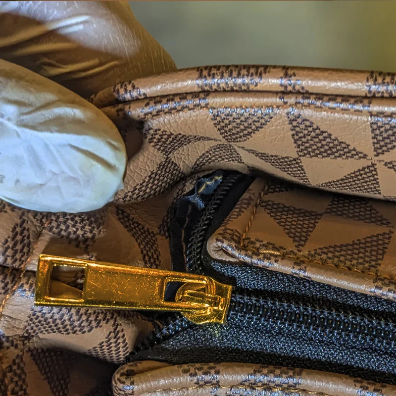 Close-up of brown geometric tote bag zipper and stitching detail