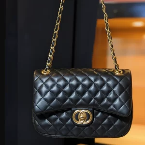 Front view of quilted black ladies crossbody bag with gold clasp and chain – Vibe Totes