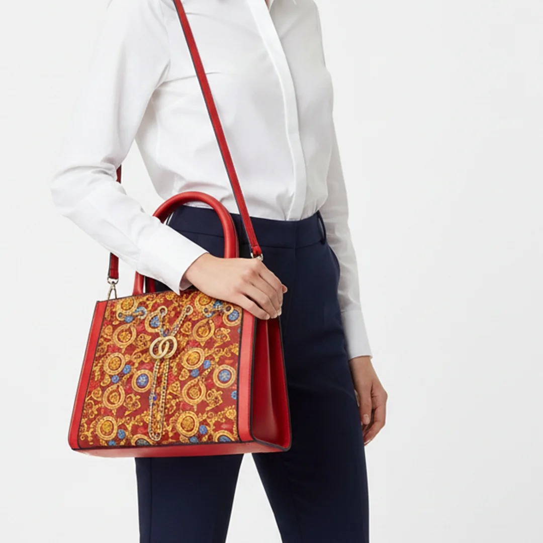 Model carrying a red multicolor ladies shoulder bag with gold chain detail from Vibe Totes