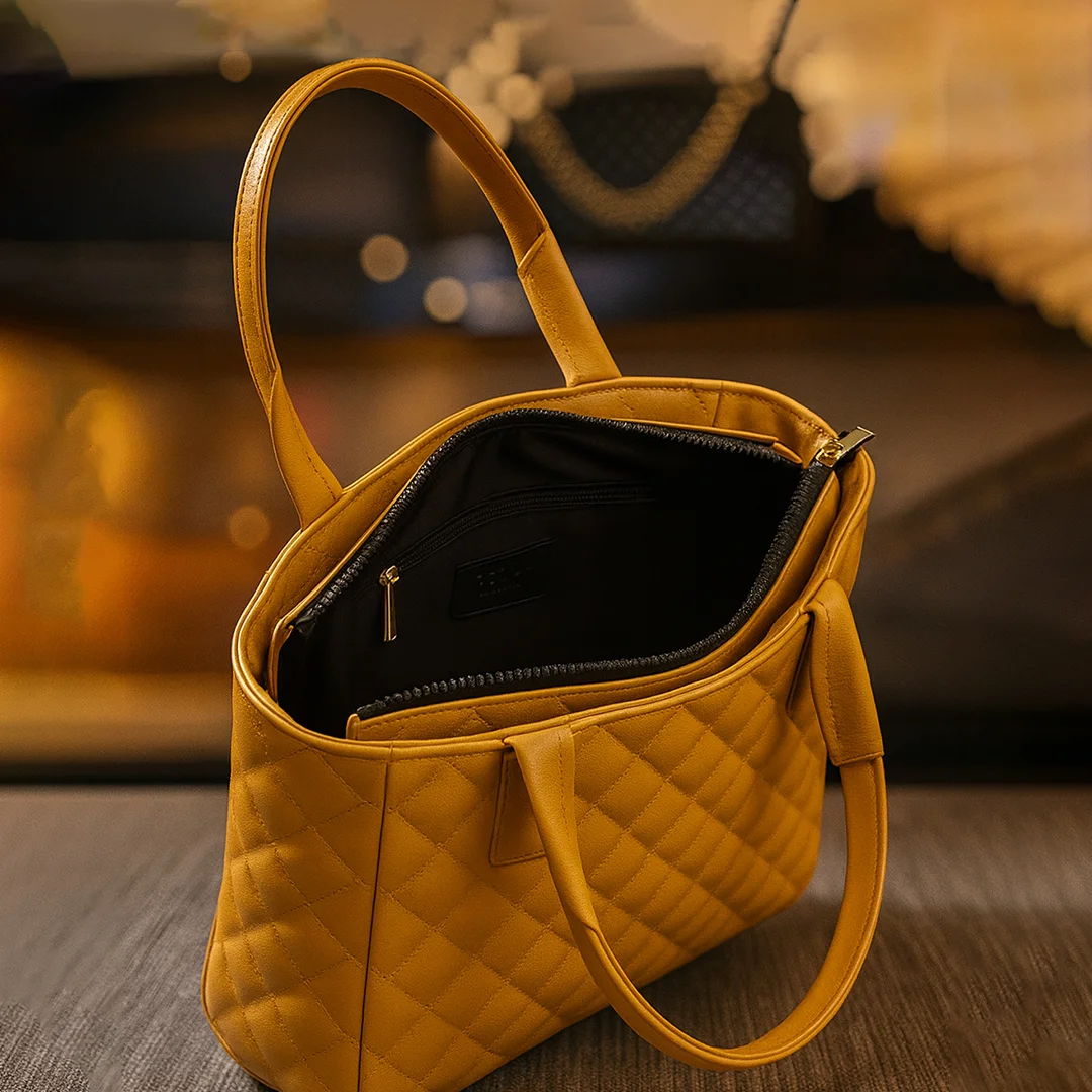 Interior view of mustard quilted shoulder bag showing zip pocket and spacious compartment