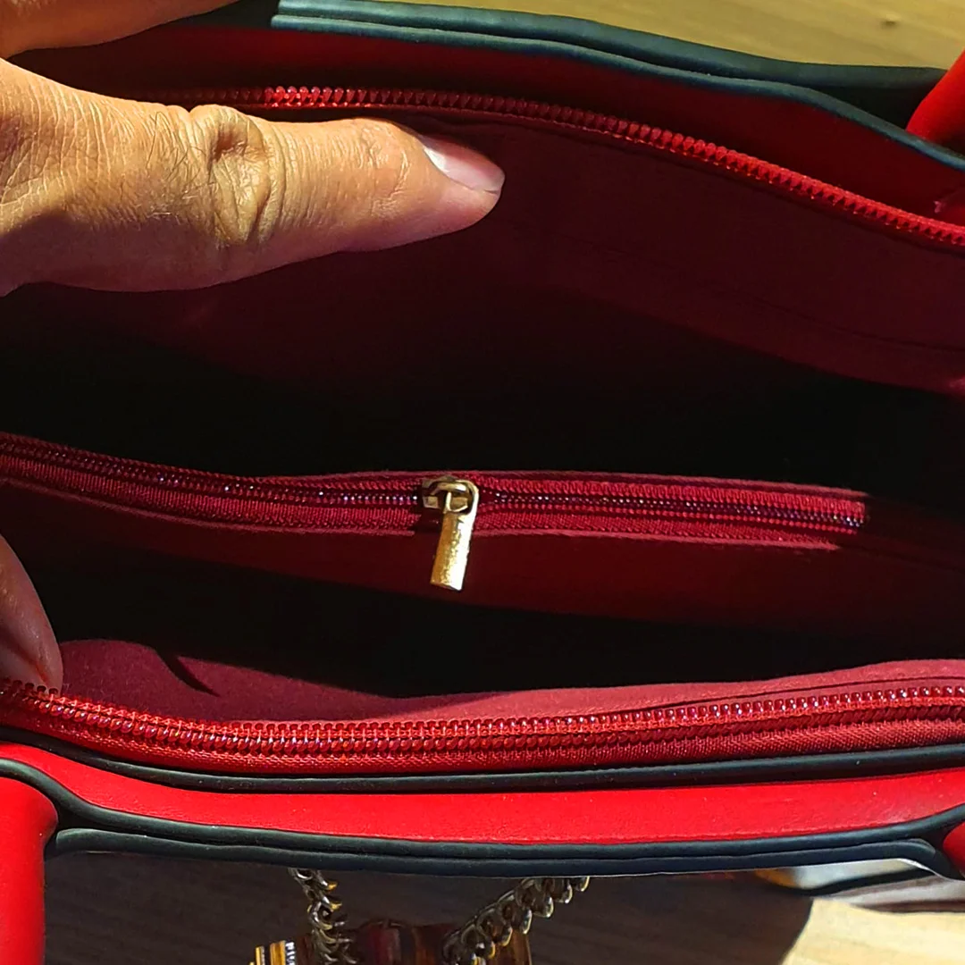 Inner view of the red multicolor ladies shoulder bag showing zipper compartments