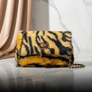 Front view of the Vibe Totes tiger print faux fur crossbody bag with gold chain strap.