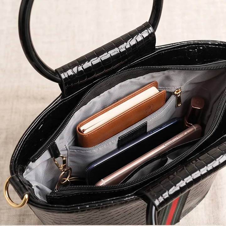 open interior view of a Vibe Totes black patent crossbody bag showing organized compartments, perfect for versatile crossbody bags.
