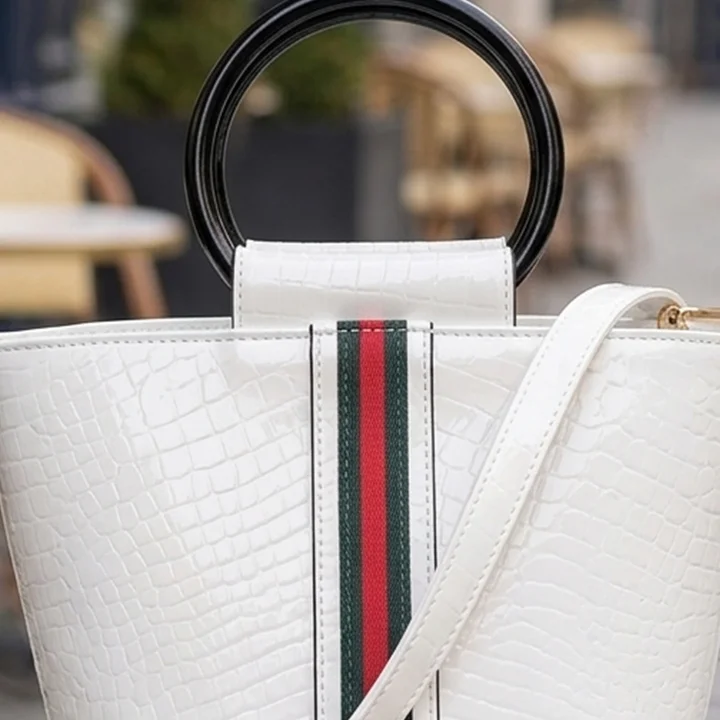 close up view of a Vibe Totes white patent crossbody bag showing organized compartments, perfect for versatile crossbody bags.